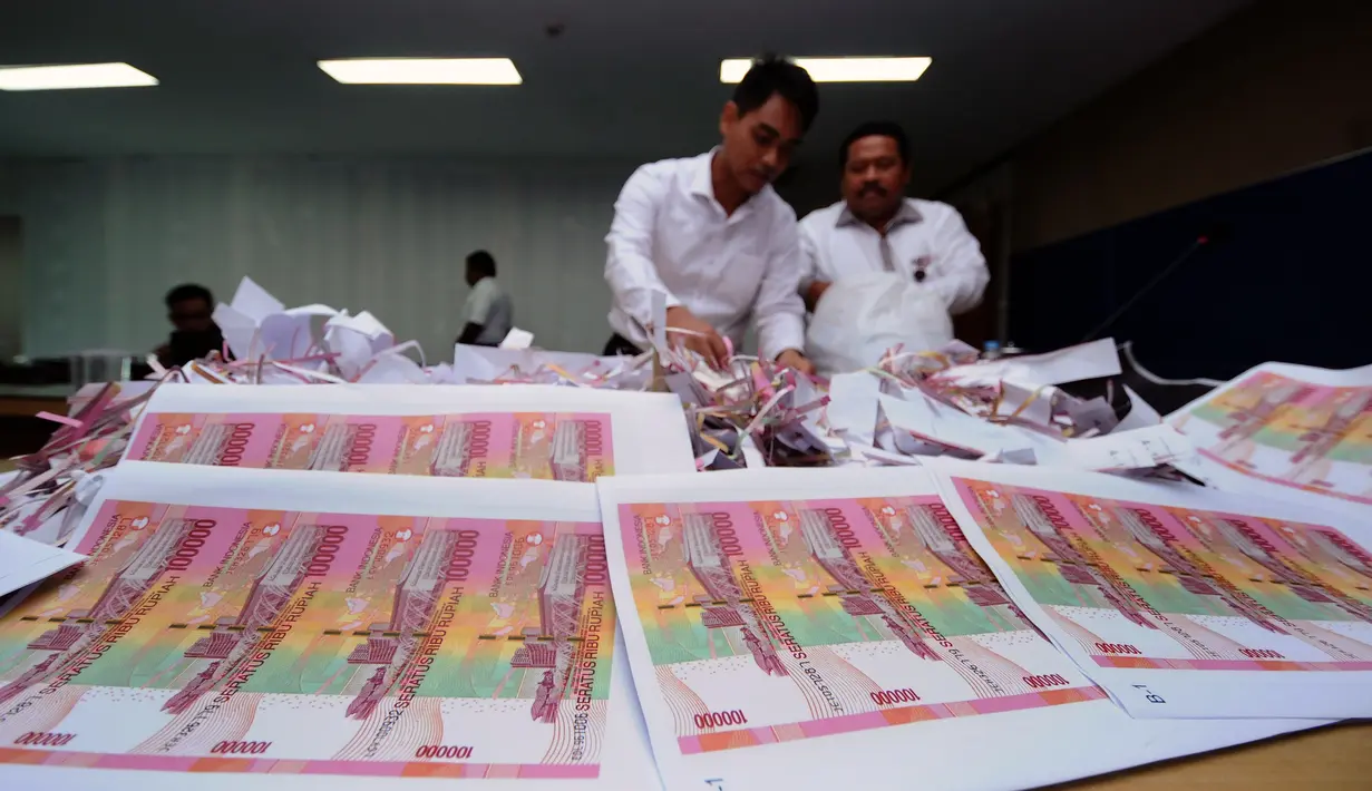 Petugas meletakkan barang bukti hasil print uang palsu saat rilis di Bareskrim Mabes Polri, Gedung KKP, Jakarta, Senin (10/10/2016). Peredaran dikendalikan dari rutan, empat tersangka diamankan dalam kasus ini. (Liputan6.com/Helmi Fithriansyah)