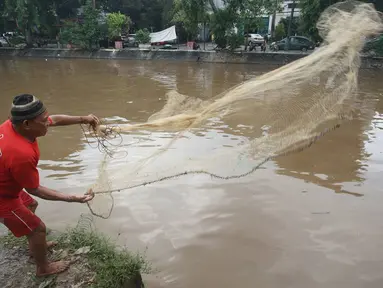 Warga memancing ikan di bantaran Sungai Ciliwung, Jakarta, Selasa (21/2). Meluapnya Sungai Ciliwung menjadi berkah tersendiri bagi warga untuk memancing dan menjala ikan yang terbawa arus dari hulu. (Liputan6.com/Immanuel Antonius)