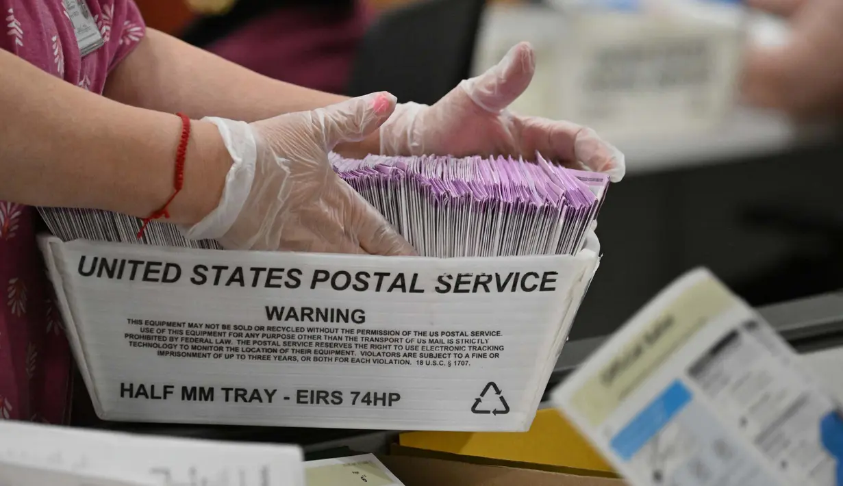 Surat suara yang masuk melalui pos akan diverifikasi terlebih dahulu sebelum masuk penghitungan di Pusat Pemrosesan Surat Suara. (Robyn Beck/AFP)