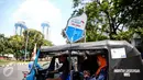 Seorang warga menaiki bajaj bahan bakar gas (BBG) gratis dikawasan Monas Jakarta, Rabu (17/8). Program bajaj gas gratis ini akan berlangsung mulai tanggal 14-20 Agustus 2016. (Liputan6.com/Faizal Fanani)