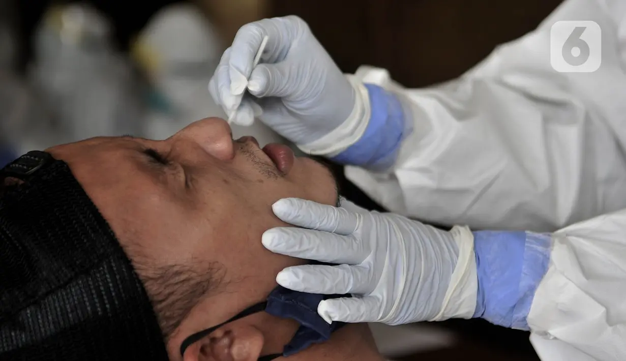 Pedagang saat menjalani Tes Swab Covid-19 di Pasar Kramat Jati, Jakarta, Rabu (17/6/2020). Ratusan pedagang Pasar Kramat Jati menjalani tes swab secara bertahap sebagai upaya pemerintah memutus rantai penyebaran virus Covid-19. (merdeka.com/Iqbal S. Nugroho)