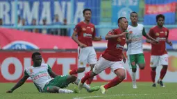 Gelandang PS TNI, Ibrahim Conteh, melakukan tekel keras saat melawan Bhayangkara FC pada laga Piala Presiden 2017 di Stadion Kanjuruhan, Malang, Sabtu (11/7/2017). Bhayangkara FC menang 2-1 atas PS TNI.(Bola.com/Reza Bachtiar)