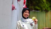 Atlet panjat tebing Indonesia, Puja Lestari dengan medali emas yang diraih di SEA Games 2025. Bola.com melakukan sesi wawancara dengan Puja di lokasi Pelatnas Panjat Tebing di Harapan Indah, Bekasi, Jawa Barat pada Rabu (14/1/2026). (Bola.com/Nur Iman Ali)