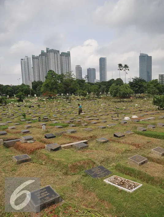 Pekerja membersihkan area makam di TPU Karet Bivak, Jakarta (2/2). Dinas Pertamanan dan Pemakaman telah menerapkan sistem online dalam pelayanan pemakaman di Ibu kota dengan alamat situs pertamananpemakaman.jakarta.go.id. (Liputan6.com/Gempur M Surya)