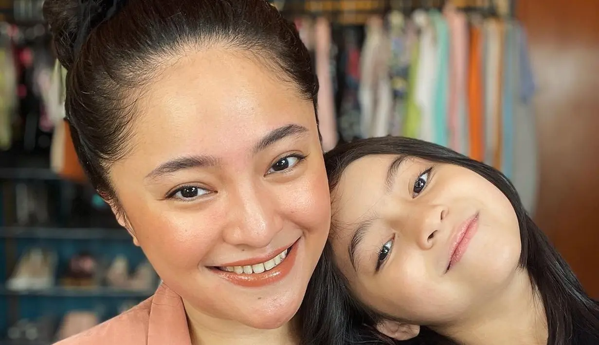 Bersandar di pundak ibunya, Sienna tersenyum cantik. Bahkan senyum keduanya pun terlihat sangat mirip. Foto: Instagram.