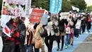 Orang-orang mengambil bagian dalam pawai untuk memprotes pernikahan antara Putri Jepang Mako dan Kei Komuro di Tokyo (26/10/2021). Putri Mako secara resmi kehilangan status kerajaannya setelah menikahi kekasih semasa kuliah, Kei Komuro pada Selasa (26/10). (AFP/Kazuhiro Nogi)