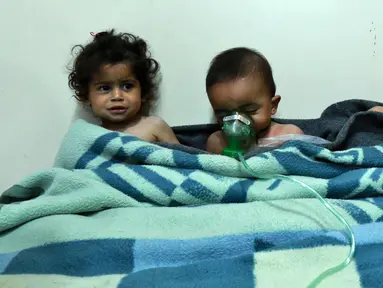 Anak-anak menerima perawatan setelah menghirup senjata kimia di klinik darurat di Desa Al-Shifuniyah, Ghouta Timur, Damaskus, Suriah, Minggu (25/2). Seorang anak meninggal dan setidaknya 13 lainnya menderita kesulitan bernapas. (HAMZA AL-AJWEH/AFP)