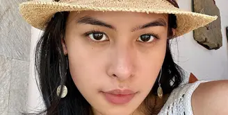 Maudy Ayunda diketahui menghabiskan liburan setelah Lebaran di Bali bersama keluarganya. Di foto ini, ia memperlihatkan potret dirinya bare face, tanpa riasan sama sekali. Ia hanya menambahkan aksesori berupa anting dan topi. Foto: Instagram.