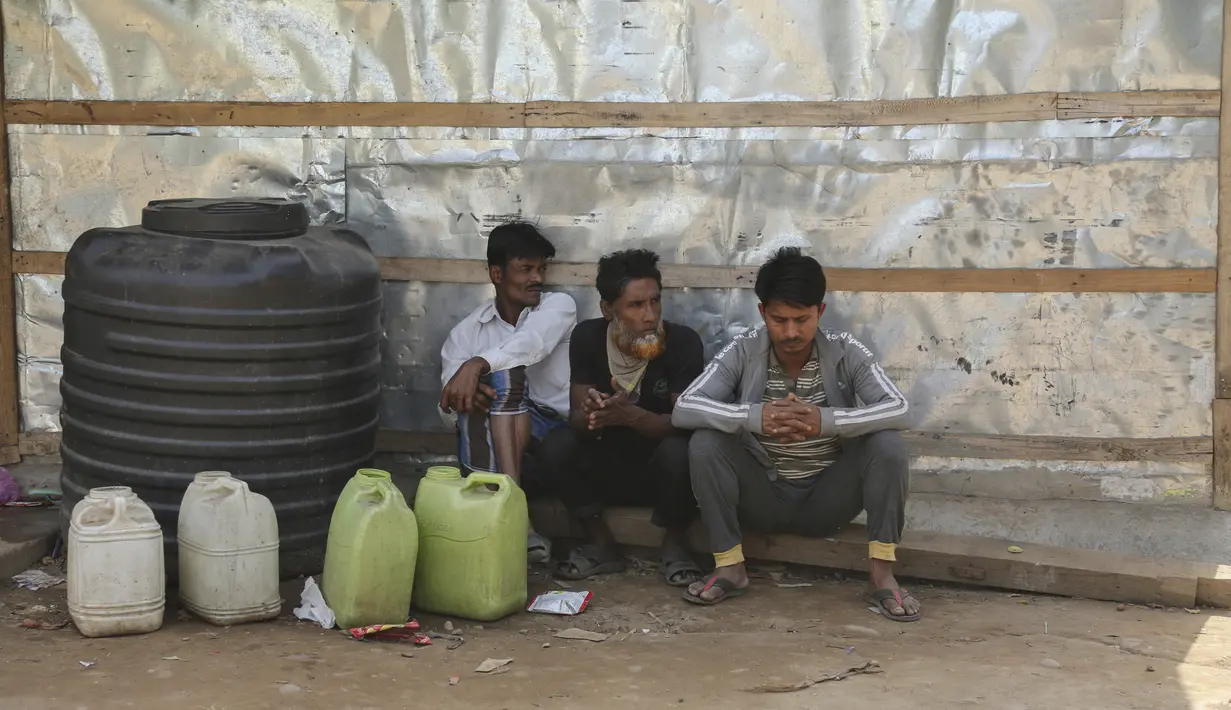 Pengungsi Rohingya duduk di luar kamp sementara mereka di pinggiran Jammu, India, 7 Maret 2021. Pihak berwenang di Kashmir yang dikuasai India telah mengirim setidaknya 168 pengungsi Rohingya ke pusat penampungan untuk mendeportasi ribuan pengungsi yang tinggal di wilayah itu (AP Photo/Channi Anand)