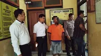 Pelaku pencabulan puluhan anak di Banyuwangi digelandang ke ruang tahanan Polsek Banyuwangi Kota (Hermawan Arifianto/Liputan6.com)