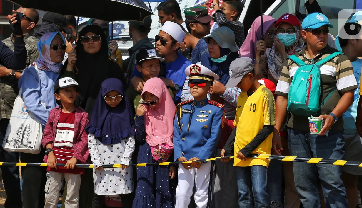 Sejumlah anak-anak antusias menyaksikan perayaan HUT ke-74 TNI di Lanud Halim Perdanakusuma, Jakarta Timur, Sabtu (5/10/2019). Warga rela panas-panasan dan berdesak-desakan untuk menyaksikan perayaan HUT ke-74 TNI. (Liputan6.com/JohanTallo)