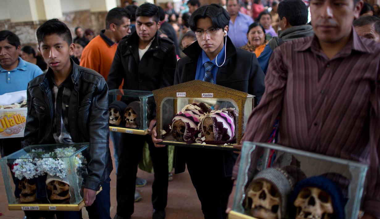 Sejumlah orang membawa tengkorak manusia yang dihias selama Festival Natitas di La Paz, Bolivia (8/11). Ritual ini digelar seminggu setelah Hari Mati di Bolivia. (AP Photo/Juan Karita)