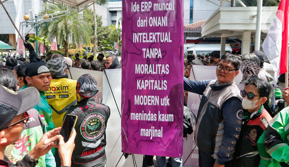 Pengemudi ojek online membentangkan spanduk tuntutan saat melakukan aksi di depan Balai Kota Jakarta, Rabu (8/2/2023). Dalam aksinya, mereka menolak penerapan jalan berbayar atau electronic road pricing (ERP) diterapkan di Jakarta. (Liputan6.com/Angga Yuniar)