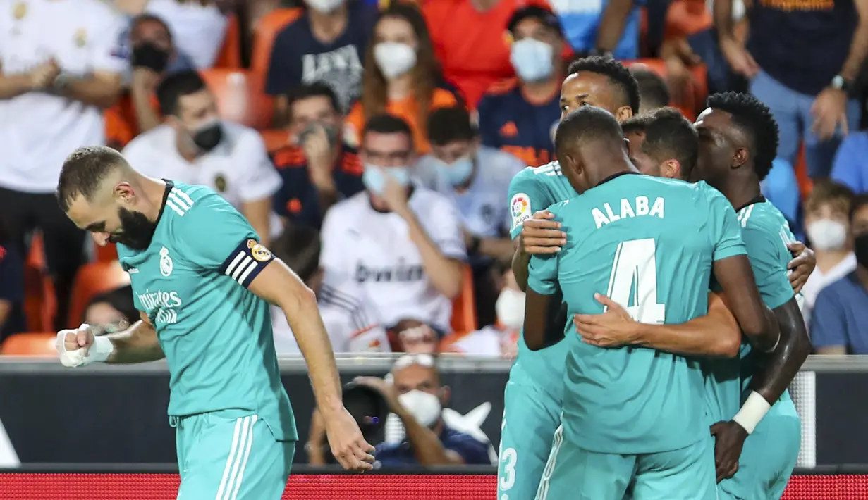 Penyerang Real Madrid Vinicius Junior berselebrasi dengan rekan setimnya setelah mencetak gol ke gawang Valencia pada lanjutan La Liga di Stadion Mestalla, Senin (20/9/2021) dini hari WIB. Real Madrid menang 2-1 secara dramatis atas Valencia. (AP Photo/Alberto Saiz)