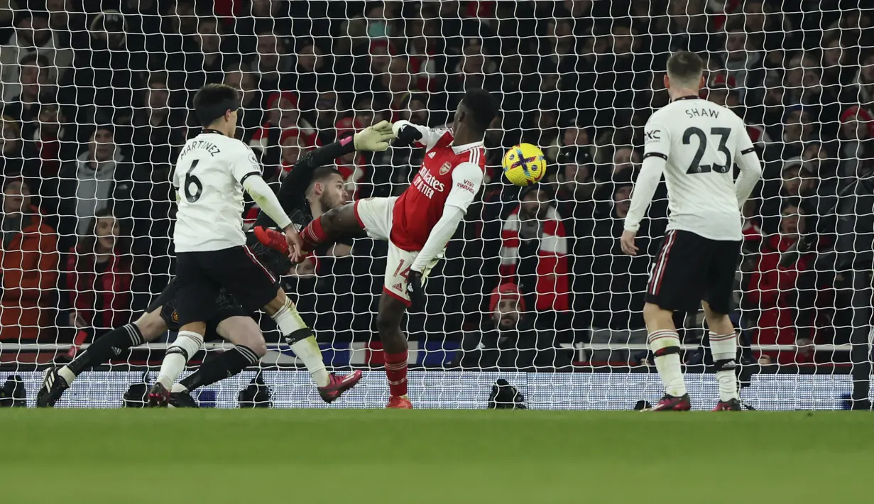 Penyerang Arsenal, Eddie Nketiah (tengah) saat mencetak gol ketiga timnya ke gawang Manchester United pada pertandingan lanjutan Liga Inggris di stadion Emirates di London, Minggu (22/1/2023). Arsenal menang tipis atas Manchester United dengan skor 3-2. (AP Photo/Ian Walton)