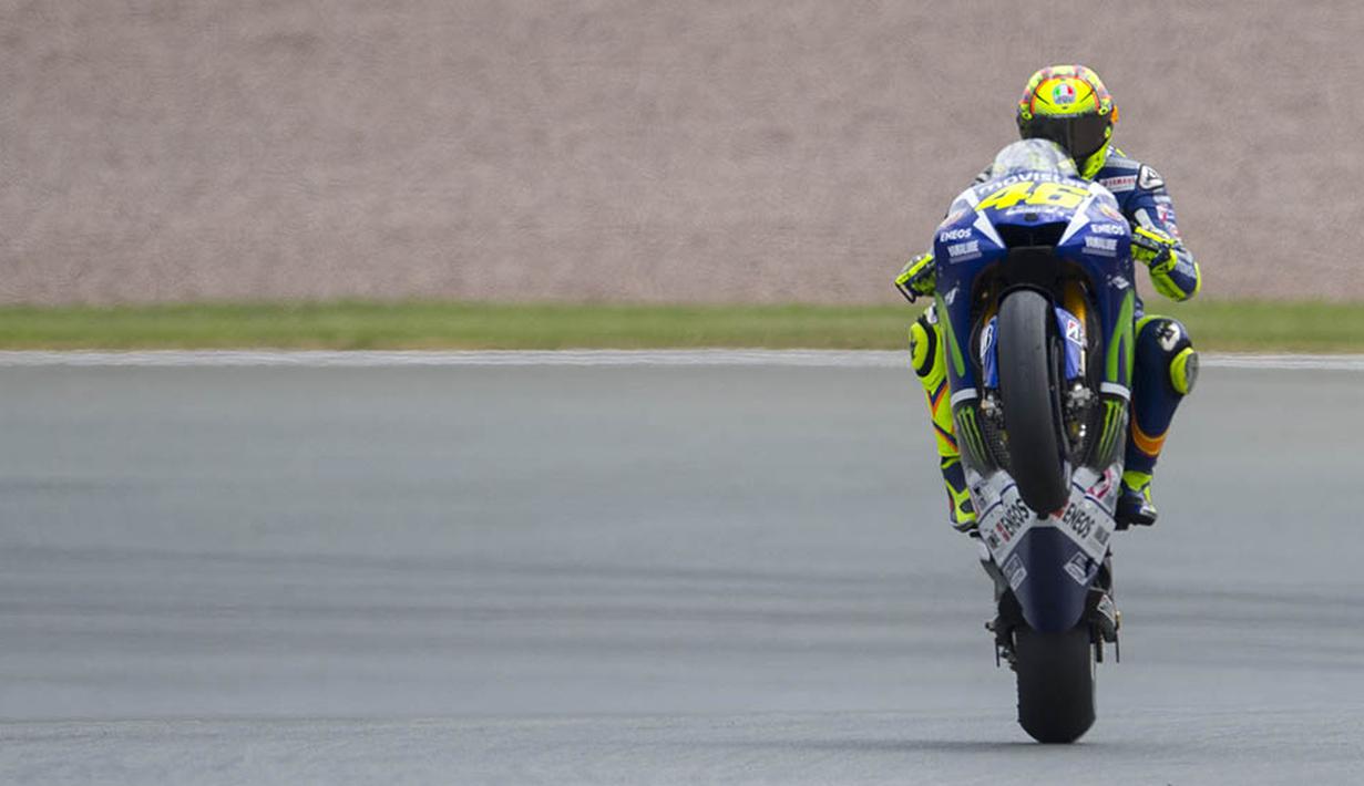 Valentino Rossi mengangkat ban depan saat sesi latihan MotoGP serie Jerman di Sirkuit Sachsenring, Jerman. (AFP/Robert Michael)