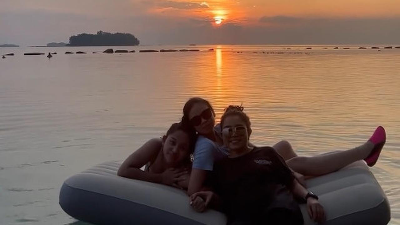 Pemandangan senja di pulau ini menakjubkan. Mayang menikmati waktu bersama putrinya di laut yang luas.