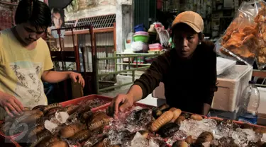 Pedagang teripang melayani calon pembeli di kawasan Petak Sembilan, Jakarta, Selasa (24/1). Jelang hari raya Imlek, teripang dan ikan Bandeng banyak dicari untuk menu makan bersama keluarga. (Liputan6.com/Yoppy Renato)