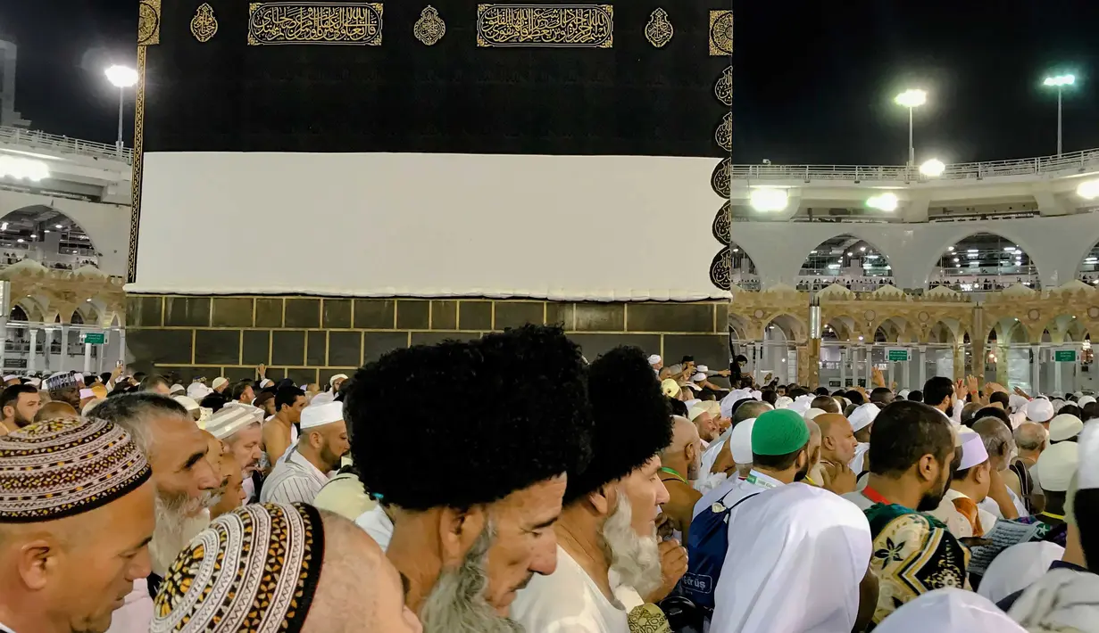 Umat muslim berjalan mengelilingi bangunan Kakbah di Masjidil Haram, Mekah, Arab Saudi, Jumat (17/8). Bangunan Kakbah dibungkus kain berwarna hitam yang disebut kiswah. (AP Photo/ Dar Yasin)