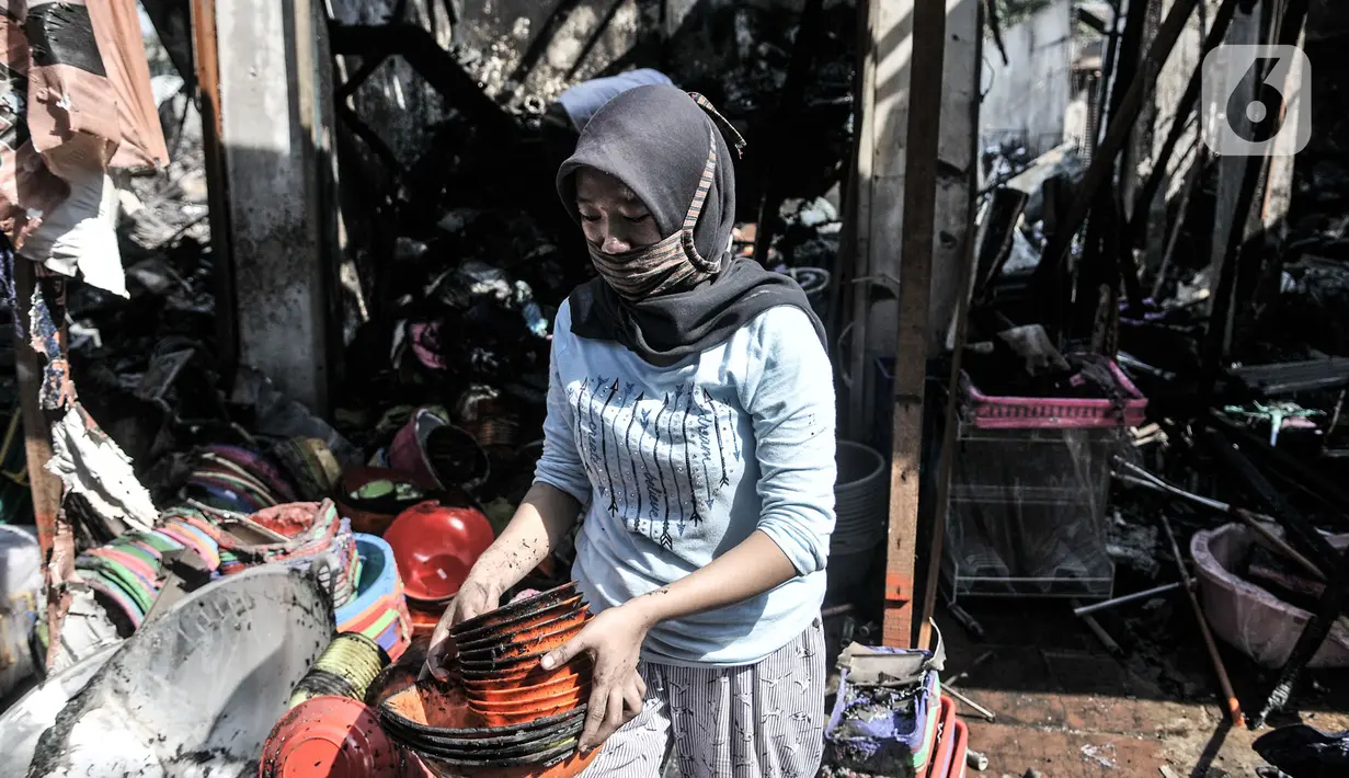 Pedagang membawa barang yang tersisa dari lokasi kebakaran Pasar Cempaka Putih, Jakarta, Kamis (24/9/2020). Kebakaran yang diduga akibat ledakan tabung gas dari lapak potong ayam tersebut menghanguskan 807 kios dengan kerugian ditaksir mencapai Rp 9 miliar. (merdeka.com/Iqbal S. Nugroho)