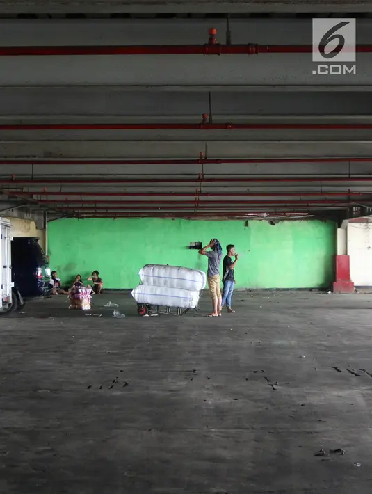 Pekerja menurunkan barang dagangan di parkir Blok F Tanah Abang, Jakarta Pusat, Selasa (24/4). Wakil Gubernur DKI Jakarta Sandiaga Uno berencana merelokasi sementara pedagang Blok G Pasar Tanah Abang ke parkiran Blok F. (Liputan6.com/Arya Manggala)