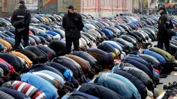Sejumlah petugas berjaga saat warga Muslim Rusia melaksanakan Salat Idul Adha di dekat Masjid Agung Moskow, Rusia, Senin (12/9). (REUTERS / Maxim Zmeyev)