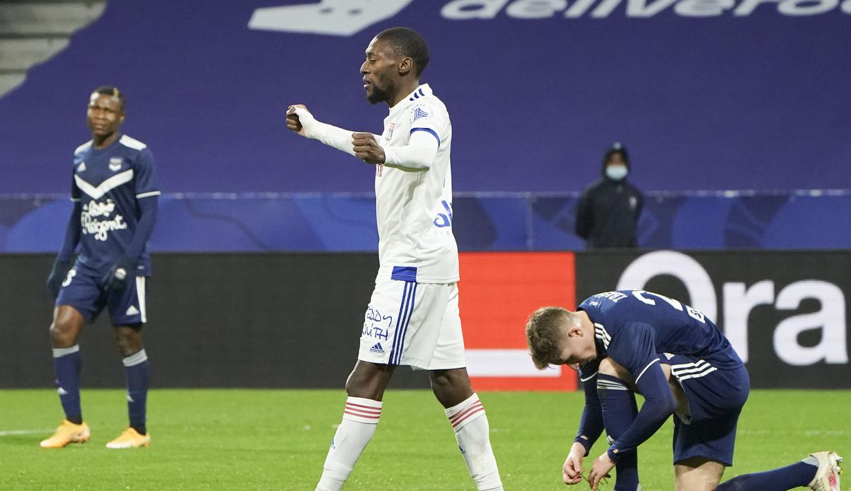 Striker Lyon, Karl Toko Ekambi (tengah) melakukan selebrasi usai mencetak gol pertama timnya ke gawang Bordeaux dalam laga lanjutan Liga Prancis 2020/21 pekan ke-22 di Groupama Stadium, Jumat (29/1/2021). Lyon menang 2-1 atas Bordeaux. (AP/Laurent Cipriani)