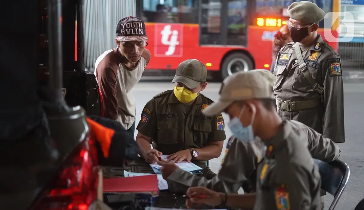 Petugas mendata warga pelanggar Operasi Yustisi Pencegahan Covid-19 di kawasan Kampung Melayu, Jakarta Timur, Senin (16/11/2020). Warga yang melanggar dikenakan sanksi berupa push up serta menyapu fasilitas umum. (Liputan6.com/Immanuel Antonius)