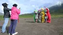 Wisawatawan mengambil gambar anaknya bersama karakter teletubbies di Bukit teletubbies kawasan Taman Nasional Bromo Tengger Semeru, Jawa Timur, Selasa (26/3). Kegiatan yang berlangsung sejak sekitar 1,5 bulan lalu ini dilakukan warga asli Tengger dengan seizin pihak TNBTS. (merdeka.com/Arie Basuki)