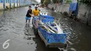 Sejumlah warga membawa ikan dengan gerobak melintasi banjir di Kawasan Muara Angke, Jakarta, Rabu (11/1). Banjir rob setiap laut pasang ini terjadi setelah tanggul laut jebol pada pertengahan tahun lalu. (Liputan6.com/Gempur M. Surya)