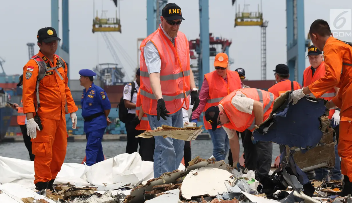 Petugas KNKT mencari dan memisahkan serpihan pesawat Lion Air JT 610 dari tumpukan barang temuan di Pelabuhan JICT 2, Jakarta, Kamis (1/11). Sebelumnya, pesawat Lion Air JT-610 jatuh diperairan utara Kerawang. (Liputan6.com/Helmi Fithriansyah)