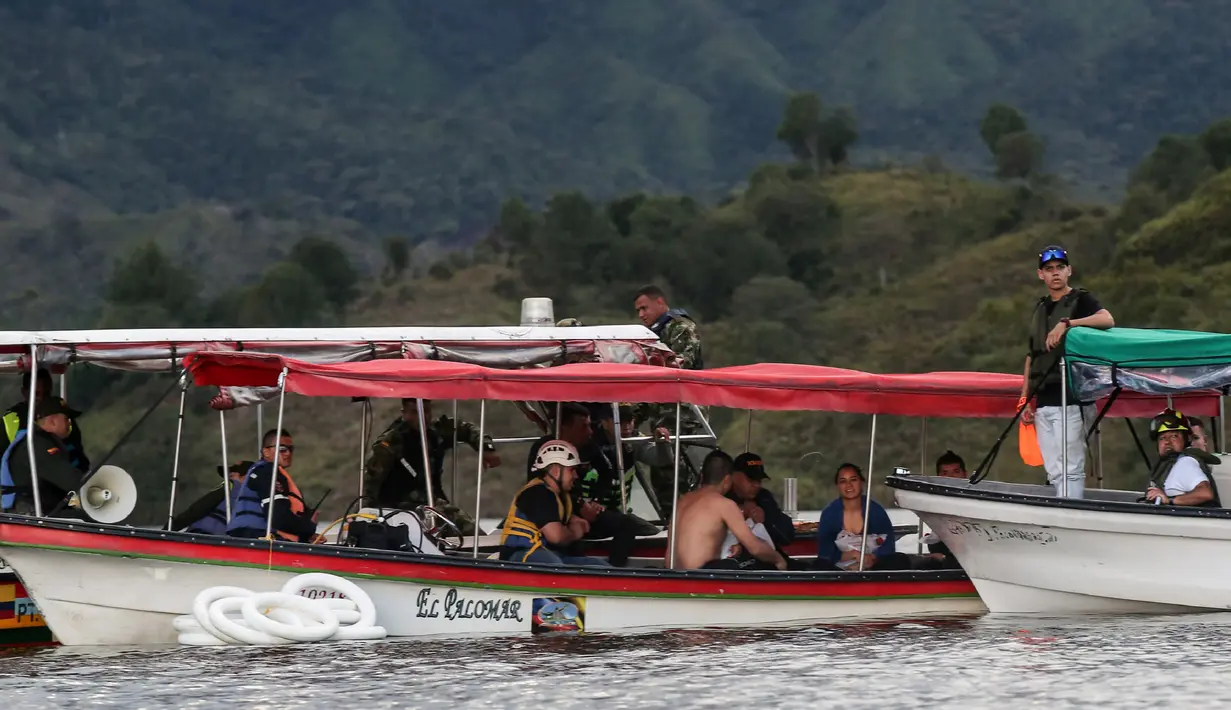 Tim penyelamat mengangkut korban tenggelamnya kapal wisata Almirante di sebuah waduk di dekat kota turis Guatape, Kolombia barat daya, Minggu (25/6). Satu helikopter dari Angkatan Udara sudah membantu untuk operasi penyelamatan. (JOAQUIN SARMIENTO / AFP)