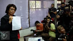 Suciwati menunjukan siaran pers Ultimatum Suciwati untuk Presiden di Jakarta, Rabu (19/10). Dalam keterangannya Kontras meminta Presiden RI Jokowi menindaklanjuti hilangnya laporan TPF kasus pembunuhan Munir di Kemensetneg. (Liputan6.com/Johan Tallo)
