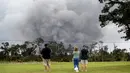 Wisatawan menyaksikan asap tebal yang berembus dari puncak gunung berapi Kilauea di Hawaii. Kamis (17/5). Para wisatawan tetap santai dan justru menjadikan letusan gunung ini sebagai objek wisata. (AP Photo/Caleb Jones)