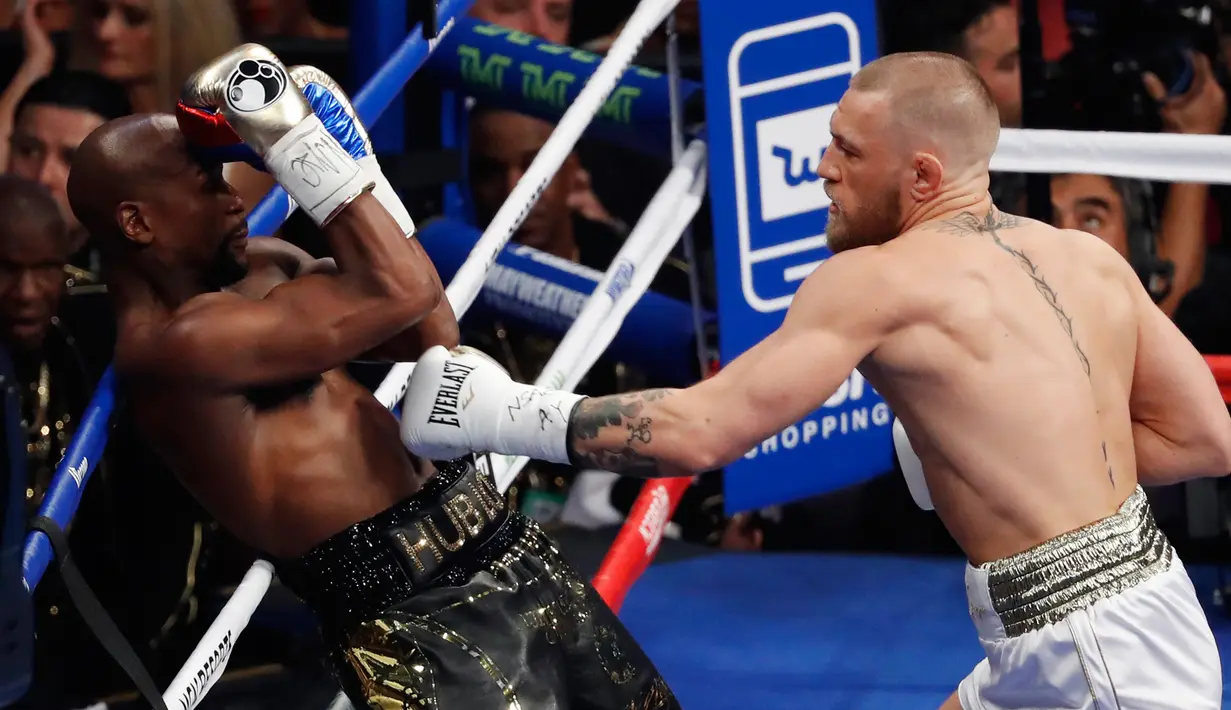 Pertandingan Floyd Mayweather melawan Conor McGregor dalam tinju super kelas welter di Las Vegas (26/8). Usai memenangkan pertandingan, Mayweather Jr juga membawa pulang sabuk khusus yang diciptakan WBC untuk pertarungan ini. (AP Photo/Isaac Brekken)