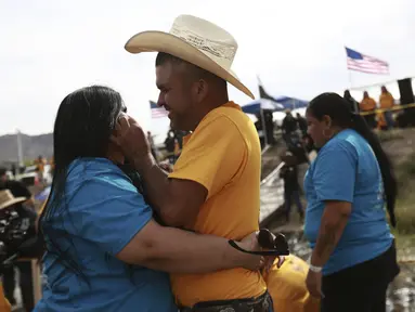Orang-orang yang tinggal di AS berpelukan dengan orang-orang yang tinggal di Meksiko selama acara tahunan ke-10 "Hugs not Walls", di bentangan Rio Grande, di Ciudad Juarez, Meksiko, Sabtu (6/5/2023). (AP Photo/Christian Chavez)