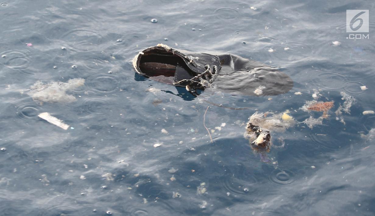 Sepatu mengambang di laut pascajatuhnya pesawat Lion Air JT 610 di laut utara Tanjung Pakis, Jawa Barat, Senin (29/10). Lion Air JT 610 hilang kontak usai lepas landas dari Bandara Soetta saat menuju Pangkalpinang. (Liputan6.com/Herman Zakharia)