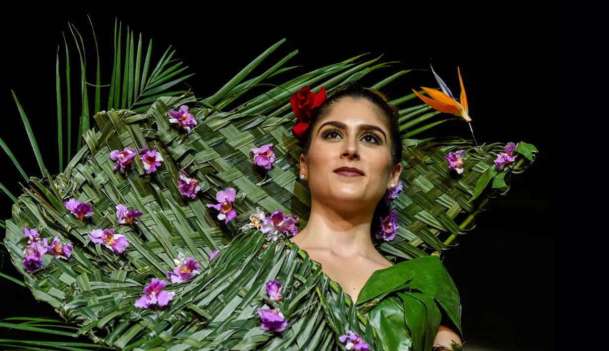 Model mengenakan busana rancangan desainer Kolombia, Estefania Russi selama BioFashion Show di Cali  pada 17 November 2018. Busana-busana yang ditampilkan di ajang ini seluruhnya terbuat dari tanaman hidup, bunga dan unsur organik lain. (Luis ROBAYO/AFP)