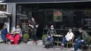 Orang-orang duduk menikmati layanan luar ruangan kafe di Roskilde Denmark, saat kafe dan bar dibuka kembali pada Rabu (21/4/2021). Denmark membuka kembali berbagai aktivitas ekonomi negaranya setelah kasus infeksi Covid-19 mengalami penurunan. (Claus Bech/Ritzau Scanpix via AP)