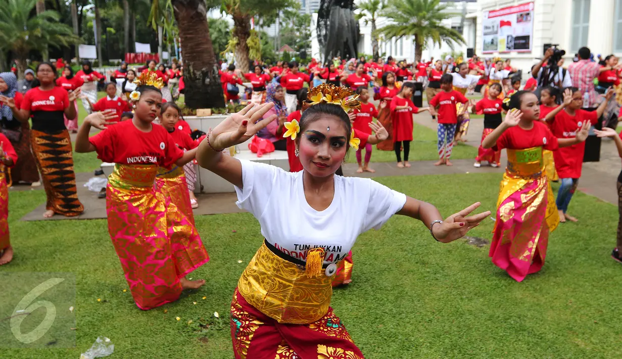 Seorang wanita melakukan pemanasan sebelum mengikuti flash mob tari pendet asal Bali di Museum Nasional Indonesia Jakarta, Sabtu (23/4). Kegiatan ini menyambut peringatan ulang tahun Museum Nasional Indonesia pada 24 April 2016 (Liputan6.com/Angga Yuniar)