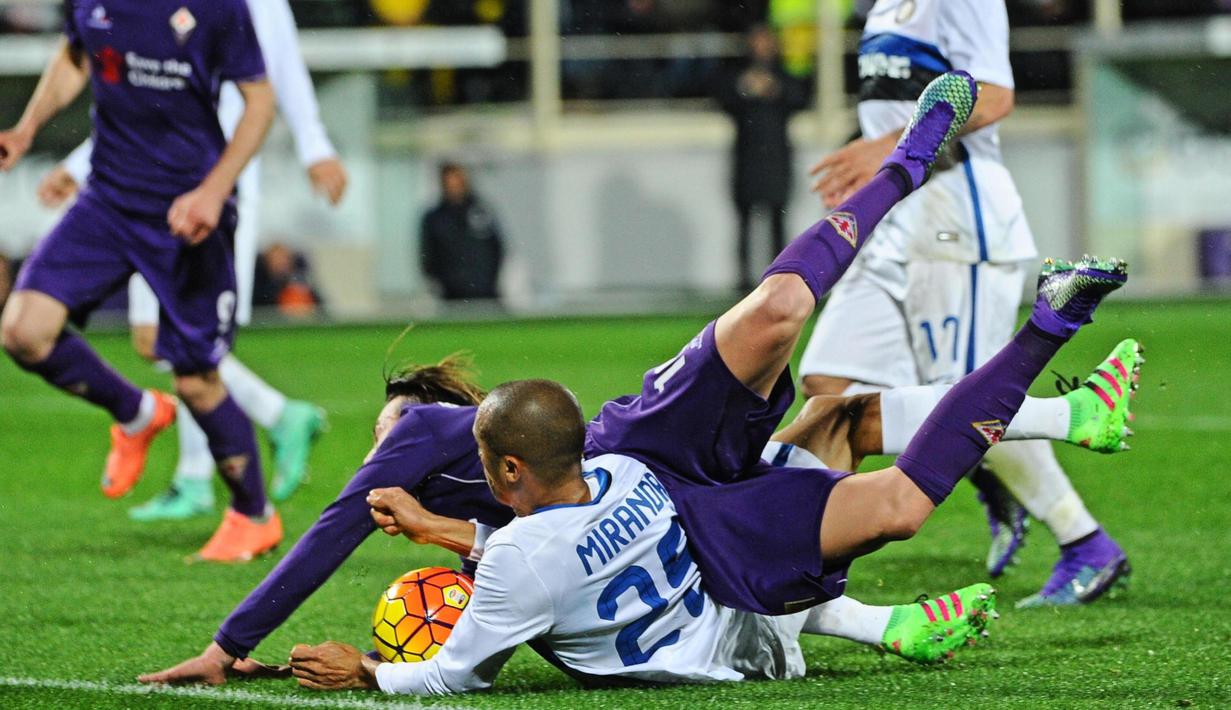 Pemain Fiorentina, Federico Bernardeschi (kiri), terjatuh saat berebut bola dengan pemain Inter, Miranda, dalam laga Serie A Italia di Stadion di Artemio Franchi, Firenze, Senin (15/2/2016) dini hari WIB. (EPA/Maurizio Degl' Innocenti)