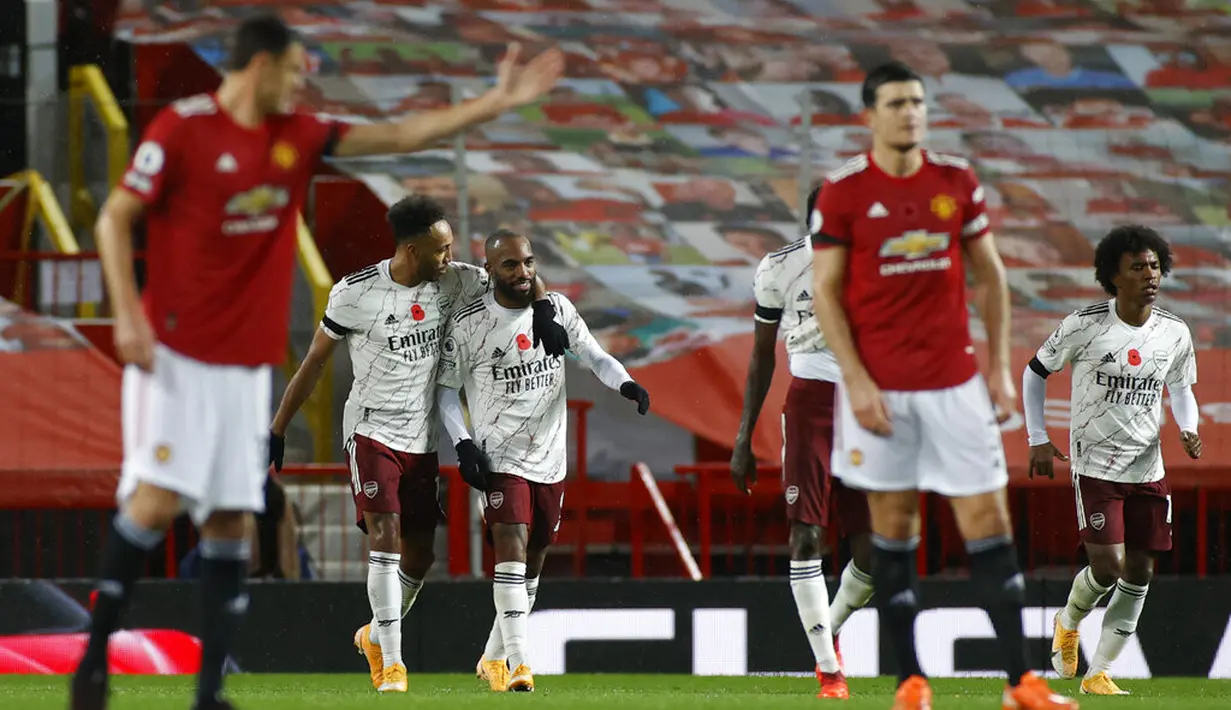 Pemain Arsenal Pierre-Emerick Aubameyang (kedua kiri) melakukan selebrasi usai mencetak gol ke gawang Manchester United pada pertandingan Liga Premier Inggris di Stadion Old Trafford, Manchester, Inggris, Minggu (1/11/2020). Arsenal menang 2-0. (Phil Noble/Pool via AP)