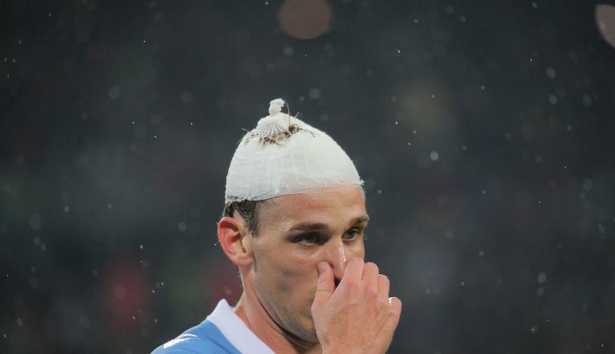 Meski cedera Lucas Biglia tetap berjibaku dengan para pemain Juventus (MARCO BERTORELLO / AFP)