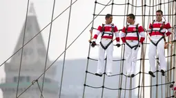 Tiga pelaut dari Angkatan Laut Peru berdiri di layar kapal saat mengikuti Parade Sail di Boston, AS (17/6). Dalam acara parade maritim ini diperkirakan 2 juta orang ikut berpartisipasi. (AP Photo / Michael Dwyer)