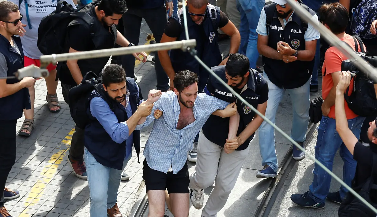 Seorang aktivis LGBT diamankan polisi berpakaian preman ketika mencoba melancarkan pawai tahunan LGBTI, di Istanbul, Minggu (26/6). Satu pekan sebelumnya, pemerintah Turki telah mengeluarkan larangan menggelar pawai tahunan LGBTI. (REUTERS/Osman Orsal)