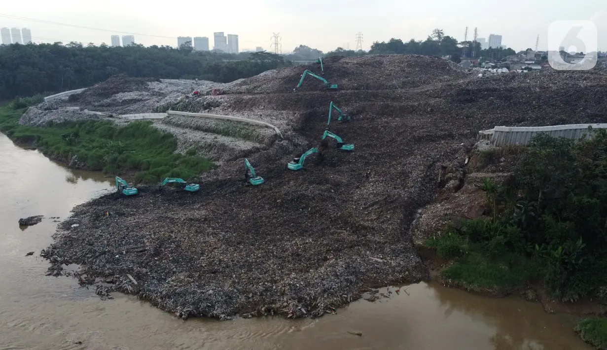 Foto udara memperlihatkan tumpukan sampah dari Tempat Pembuangan Akhir (TPA) Cipeucang masuk ke area Sungai Cisadane, Serpong, Tangerang Selatan, Rabu (3/6/2020). Sebelumnya, pada Jumat (22/5/) lalu turap yang menopang tumpukan sampah di TPA tersebut jebol. (Liputan6.com/Helmi Fithriansyah)