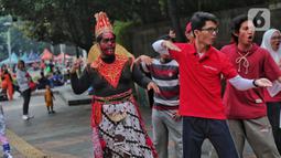 Sejumlah mahasiswa melakukan paduan suara dan gerak tari saat Car Free Day, di Jakarta, Minggu (25/9/2022). Pagelaran ini merupakan bentuk pengenalan seni kepada masyarakat yang tengah melakukan aktivitas di CFD. (Liputan6.com/Angga Yuniar)