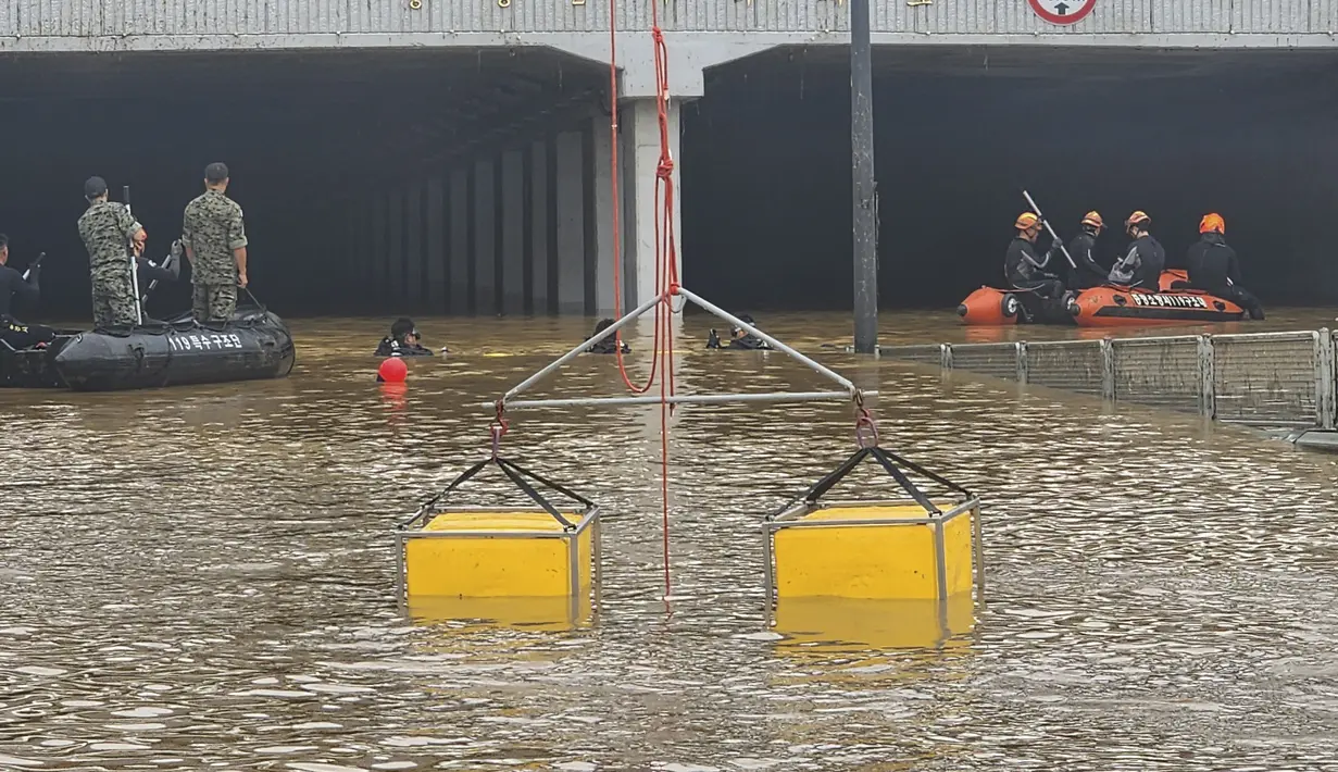 Petugas penyelamat Korea Selatan menarik tujuh mayat dari terowongan banjir di mana sekitar 15 kendaraan terjebak dalam air berlumpur. (South Korea National Fire Agency via AP)