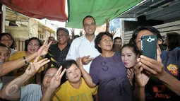 Cagub DKI Jakarta Anies Baswedan berfoto bersama warga yang bermukim di bantaran Kali Krukut, Jakarta Barat, Kamis (3/11). Kepada warga, Anies berjanji memprioritaskan penataan wilayah tanpa melanggar prinsip kemanusiaan. (Liputan6.com/Yoppy Renato)
