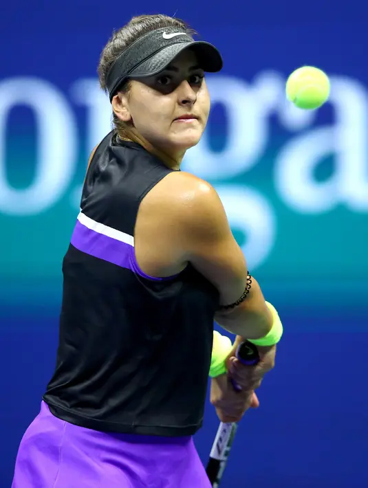 Petenis Kanada, Bianca Andreescu mengembalikan bola ke arah petenis Swiss, Belinda Bencic pada babak semifinal AS Terbuka di Arthur Ashe Stadium, Kamis (6/9/2019). Petenis berusia 19 tahun itu mengamankan tiket ke final usai menang dengan skor 7-6 (7-3) dan 7-5. (Clive Brunskill/Getty Images/AFP)